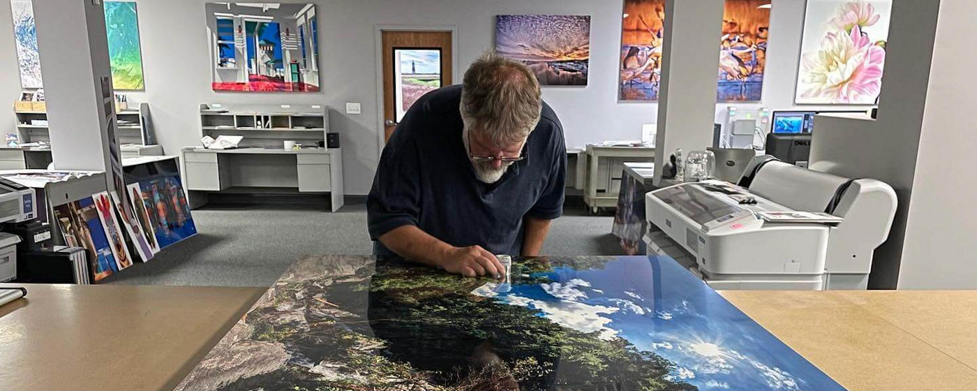 A man inspecting an image printed on metal